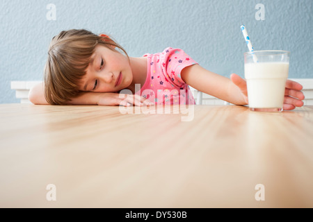 Mädchen auf der Suche auf Glas Milch Stockfoto