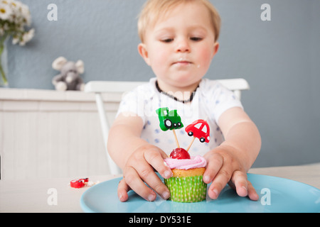 Baby Junge spielt mit cupcake Stockfoto