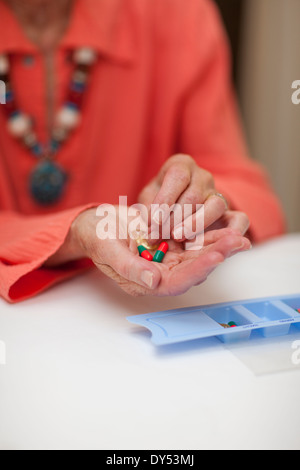 Ältere Frau mit Medikamenten von Pillbox hautnah Stockfoto