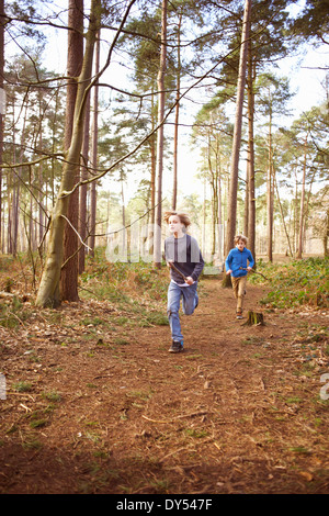 Zwillingsbrüder racing einander durch Wald Stockfoto