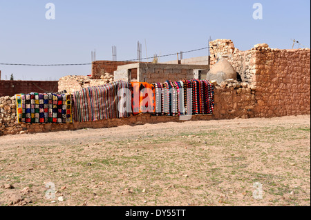 Traditionelle marokkanische Teppiche Lüften auf Stein Bruchsteinmauer, Dorf Amasse N'Kik in Atlas Ausläufern außerhalb Marrakesch Stockfoto