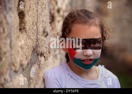 Jerusalem, Jerusalem, Palästina. 7. April 2014. Ein palästinensisches Mädchen mit ihrer Nationalflagge auf ihr Gesicht gemalt beteiligt sich an einem Feierlichkeiten den Internationalen Kindertag in Jerusalem am 7. April 2014 Credit: Saeed Qaq/APA Images/ZUMAPRESS.com/Alamy Live News Stockfoto