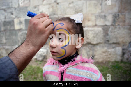 Jerusalem, Jerusalem, Palästina. 7. April 2014. Ein palästinensisches Mädchen hat auf ihrem Gesicht gemalt, während einer Feier anlässlich Internationaler Kindertag in Jerusalem am 7. April 2014 Credit: Saeed Qaq/APA Images/ZUMAPRESS.com/Alamy Live News Stockfoto