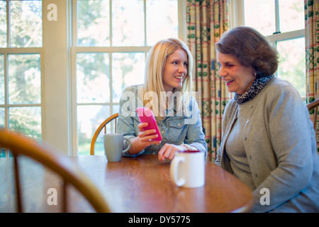 Ältere Frau und Enkelin Smartphone betrachten Stockfoto