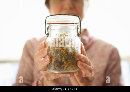 Gesunde Lebensmittel Ladenbesitzer halten Glas mit Johanniskraut Stockfoto