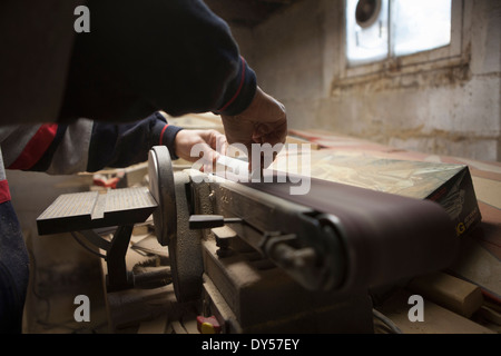 Nahaufnahme von reifer Mann mit Schleifband in Werkstatt Stockfoto