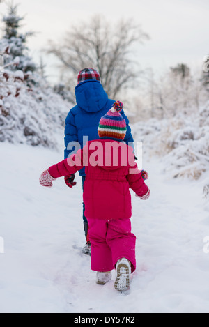 Bruder und Schwester zu Fuß im Schnee Stockfoto