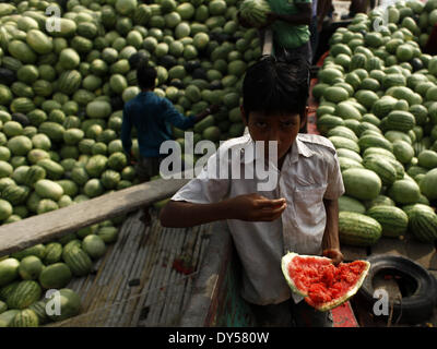 Dhaka, Bangladesch. 7. April 2014. Eine Straße junge Suche nach essbaren Wassermelonen vom Fluss Buriganga verschmutzt und verdreckt. Stoßstange Produktion der Wassermelone in Bangladesch in dieser Saison. Experten sagten, dass die gute Qualität Wassermelonen waren eine Rekordernte in diesem Jahr wegen Begünstigung Wetter und Landwirtschaft verbessert. Zakir Hossain © Chowdhury/NurPhoto/ZUMAPRESS.com/Alamy Live-Nachrichten Stockfoto