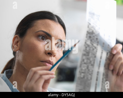 Weiblicher Wissenschaftler untersuchen DNA-gel im Labor für genetische Forschung Stockfoto