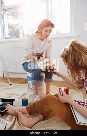 Zwei Teenager-Schwestern mit Farbfeldern, Kaffee und eine Katze Stockfoto