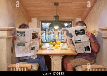 Zu zweit am Frühstückstisch, ignorieren einander, Zeitung zu lesen Stockfoto
