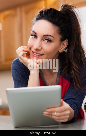 Porträt der jungen Frau in Küche hält digital-Tablette Stockfoto