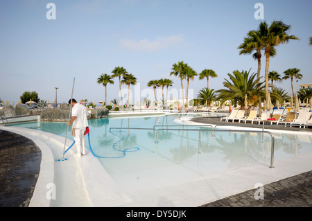 Ein Mann ist in einem schönen Hotelresort Poolreinigung. Stockfoto