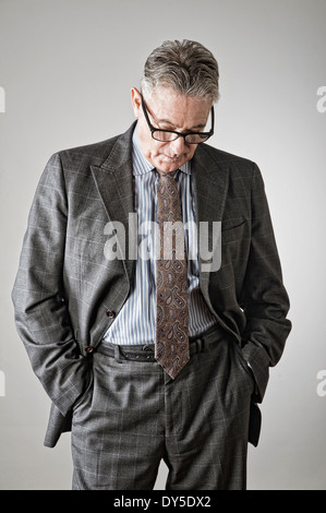 Ältere Mann mit Händen in den Taschen, Blick nach unten Stockfoto