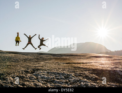 Drei junge weibliche Wanderer springen Luft auf Felsen, Squamish, British Columbia, Kanada Stockfoto