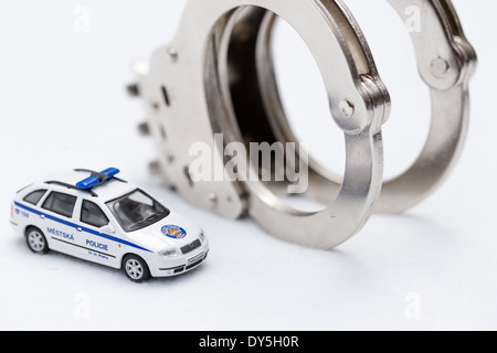 Fesseln mit Modell der Polizeiwagen auf weißem Hintergrund Stockfoto