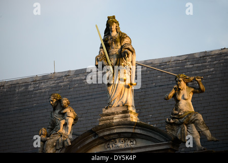 BRÜGGE, Belgien — Eine Statue der Gerechtigkeit krönt das barocke Provosthaus (Proosdij) auf dem Burgplatz, erbaut 1666. Das historische Gebäude diente ursprünglich als Residenz des Bischofs und beherbergt heute die Provinzbüros von Westflandern. Die barocke Architektur des Gebäudes bildet einen markanten Kontrast zum gotischen Rathaus gegenüber. Stockfoto