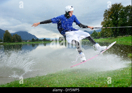 Junger Mann, Wakeboard, Wakeboarden am Neubeurer See Surfen sehen, Neubeuern, Rosenheim, Upper Bavaria, Bavaria, Germany Stockfoto