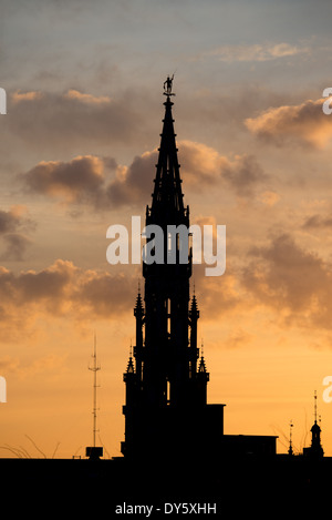 BRÜSSEL, Belgien – die Silhouette der Brüsseler Skyline bei Sonnenuntergang vor einem goldenen Himmel mit einigen Wolken. Der hohe Turm des Brüsseler Rathauses (Hotel de Ville) ist 96 Meter entfernt. Stockfoto