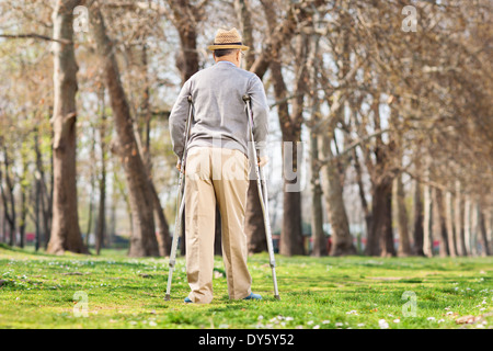 Alter Mann mit Krücken, walking im freien Stockfoto