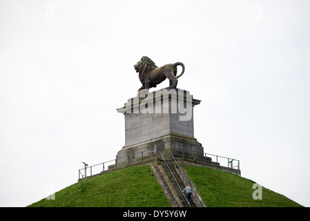 Löwenhügel Löwenstatue Waterloo Belgien // WATERLOO, Belgien — die monumentale gusseiserne Löwenstatue auf dem Löwenhügel (Butte du Löwe) steht als Symbol des Friedens, der nach den Napoleonischen Kriegen nach Europa zurückkehrte. Die 28 Tonnen schwere Skulptur wurde vom Malines Künstler Van Geel entworfen und in Cockerills Eisenwerk in Lüttich gegossen. Sie liegt auf dem 141 Meter hohen künstlichen Hügel. Die Statue markiert die Stelle, an der der Prinz von Orange während der Schlacht von Waterloo verwundet wurde, als er Wellingtons erstes Korps befehligte. Stockfoto