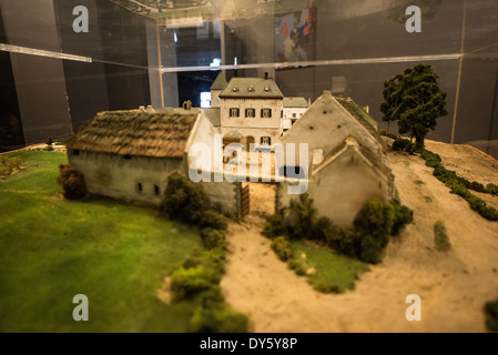 WATERLOO, Belgien — WATERLOO, Belgien — Ein Modell des Chateau d'Hougoumont, eines großen Bauernhous, der während der Schlacht von Waterloo bitter umstritten wurde. Das Modell befindet sich im Untergeschoss des Panorama der Schlacht von Waterloo, erbaut im Jahr 1912 für die hundertjährigen Feierlichkeiten der Schlacht und neben dem Butte du Lion (Löwenhügel) auf dem ehemaligen Schlachtfeld. Das Gemälde an der Wand ist 100 Meter lang und 12 Meter hoch und wurde von Louis Dumoulin und einem Team von Militärkünstlern gemalt. Es zeigt das Schlachtfeld gegen 6 Uhr am 18. Juni 1815. Das historische Schlachtfeld von Waterloo, wo Napol Stockfoto