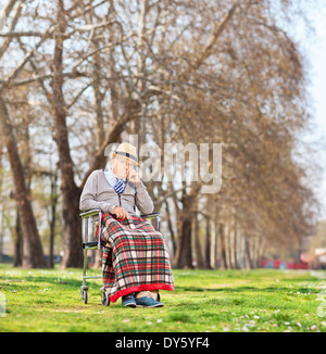 Besorgt, senior sitzt in einem Rollstuhl im park Stockfoto