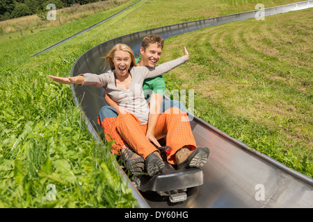 Junges Paar genießen alpine Coaster Rodelbahn im Sommer begeistert Stockfoto