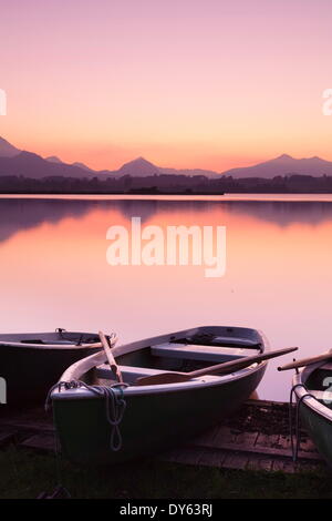 Ruderboote am Hopfensee See bei Sonnenuntergang, in der Nähe von Füssen, Allgäu, Allgäu-Alpen, Bayern, Deutschland, Europa Stockfoto