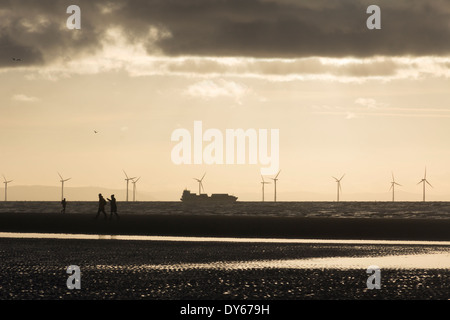 Eine Silhouette Containerschiff vorbei die Windenergieanlagen der Offshore-Windpark Burbo Bank, Liverpool Bay Ausgangspunkt Formby. Stockfoto