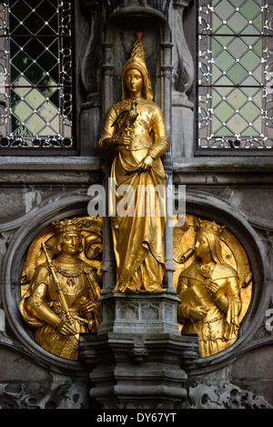 Basilika des Heiligen Blutes vergoldete Statue Brügge Belgien // BRÜGGE, Belgien — Eine vergoldete Statue, die eine Edelfrau mit einem Falken zeigt, ziert die Außenseite der Basilika des Heiligen Blutes auf dem Burgplatz. Dieses mittelalterliche Skulpturendetail kombiniert königliche Bilder mit Falknerei-Symbolik und spiegelt die kulturellen Traditionen des mittelalterlichen Adels wider. Die goldene Figur trägt zum aufwendigen gotischen Dekorationsprogramm der Basilika bei. Stockfoto