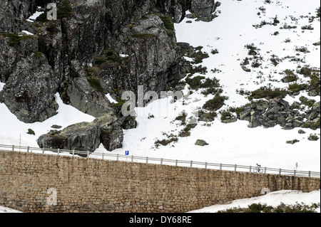 Radsportler, ein Rennrad auf einer Schnee bedeckten Bergstraße Stockfoto