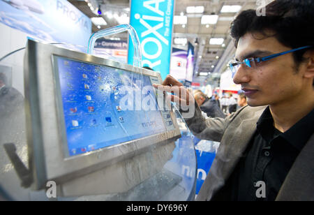 Hannover, Deutschland. 7. April 2014. Ein Messebesucher sieht ein Industrie-PC von Comüany Noax Technologies auf der Hannovermesse in Hannover, Deutschland, 7. April 2014. Der Computer ist wasserdicht, bietet gegenüber Chemikalien und Temperaturen von 330 bis 45 Grad Celsius standhalten. Der Computer war für die Lebensmittelindustrie entwickelt. Foto: Christoph Schmidt/Dpa/Alamy Live News Stockfoto