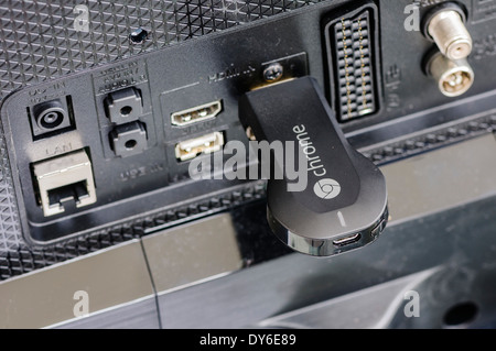 Google Chromecast TV-Streaming-Gerät an den HDMI-Anschluss des Fernsehers angeschlossen Stockfoto