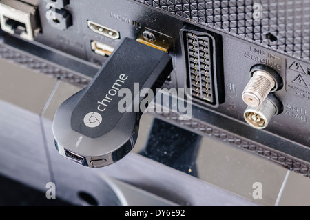 Google Chromecast TV-Streaming-Gerät an den HDMI-Anschluss des Fernsehers angeschlossen Stockfoto