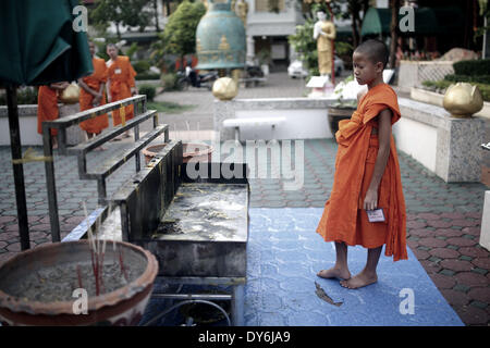 Chiang Rai, Muang, Thailand. 8. April 2014. Ein junger Novize befasst sich mit der Asche des ausgebrannten Weihrauch an der berühmten Wat(temple) Phra Singh In Chiang Rai, Nordthailand © Rohan Radheya/ZUMAPRESS.com/Alamy Live-Nachrichten Stockfoto