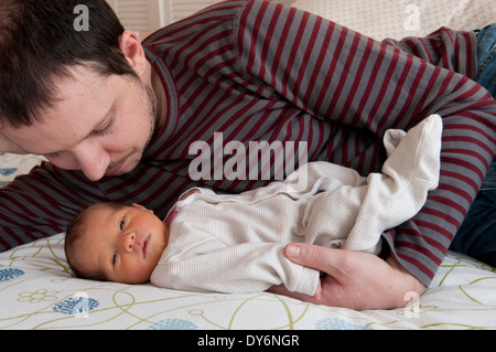 Vater kuscheln und blickte auf sein neugeborenes Babymädchen Stockfoto