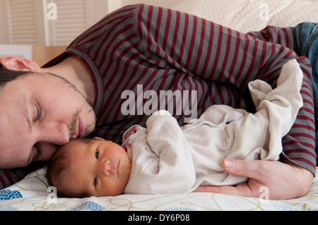 Vater mit seinem neugeborenen Mädchen kuscheln liegend Stockfoto