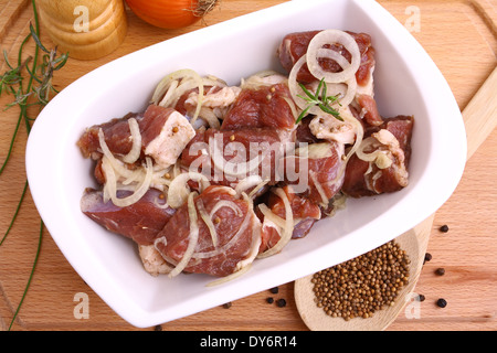 Mariniertes Lamm mit Zwiebelringen und Gewürzen, Ansicht von oben Stockfoto