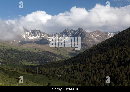 Andorra la Vella im Sommer mit einem Baum bedeckt Hügel und Skipisten und Pyrenäen im Hintergrund Stockfoto