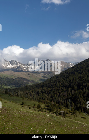 Andorra la Vella im Sommer mit einem Baum bedeckt Hügel und Skipisten und Pyrenäen im Hintergrund Stockfoto