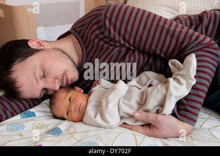 Vater mit seinem neugeborenen Mädchen kuscheln liegend Stockfoto