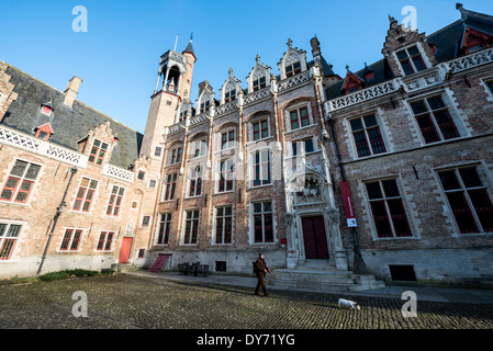 BRÜGGE, Belgien - Ein Mann führt seinen Hund am frühen Morgen auf der kopfsteingepflasterten Straße in der Nähe des Burg im historischen Zentrum von Brügge, Belgien, aus. Mittelalterliche Architektur und ruhige Kanäle prägen das Stadtbild von Brügge, oft als „Venedig des Nordens“ bezeichnet. Brügge gehört zum UNESCO-Weltkulturerbe und bietet Besuchern eine Reise in die Vergangenheit Europas mit seinen gut erhaltenen Gebäuden und kopfsteingepflasterten Straßen, die die reiche Geschichte der Stadt widerspiegeln. Stockfoto