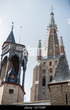 Kirche der Muttergottes Brügge Belgien // BRÜGGE, Belgien — der hoch aufragende gotische Turm der Muttergottes (Onze-Lieve-Vrouwekerk) dominiert die mittelalterliche Skyline von Brügge. Dieses architektonische Meisterwerk erhebt sich deutlich über dem historischen Zentrum und ist eines der bekanntesten Wahrzeichen der Stadt. Der Turm ist ein Beispiel für die anspruchsvolle Technik und künstlerische Leistung der mittelalterlichen gotischen Architektur. Stockfoto