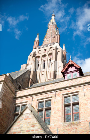 BRÜGGE, Belgien – der hoch aufragende gotische Turm der Marienkirche (Onze-Lieve-Vrouwekerk) dominiert die mittelalterliche Skyline von Brügge. Dieses architektonische Meisterwerk erhebt sich deutlich über dem historischen Zentrum und ist eines der bekanntesten Wahrzeichen der Stadt. Der Turm ist ein Beispiel für die anspruchsvolle Technik und künstlerische Leistung der mittelalterlichen gotischen Architektur. Stockfoto