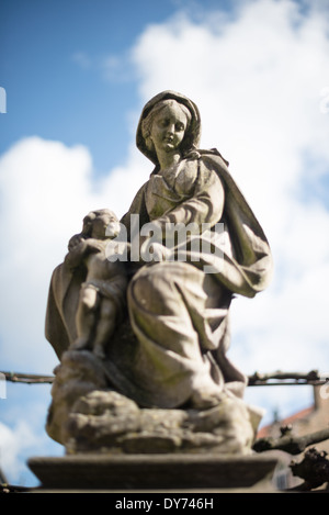 BRÜGGE, Belgien – Eine Steinstatue von Madonna und Kind ziert den Eingang zur Kirche unserer Lieben Frau (Onze-Lieve-Vrouwekerk), die die Widmung der Kirche an die Jungfrau Maria darstellt. Diese religiöse Skulptur ist ein Beispiel für mittelalterliche Marienfrömmigkeit und gotische architektonische Dekoration. Die markante Platzierung der Statue am Eingang der Kirche zeigt die Bedeutung der Jungfrau Maria für die mittelalterliche christliche Anbetung. Stockfoto