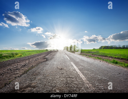 Asphaltierte Highway in das Feld und Sonnenlicht Stockfoto