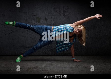 Moderne Tänzerin Posen vor dem Hintergrund des Grunge Betonwand Stockfoto