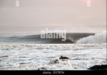 Kalten Winterwellen brechen in Coney Strand Porthcawl Südwales mit ablandigem Wind Stockfoto