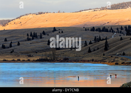 41,674.04239 drei 3 Männer Eisfischen auf glatten blauen Eis bedeckt gefrorenen See Nicola "kein Schnee" "schneefrei" Sonnenuntergang Hügellandschaft Stockfoto